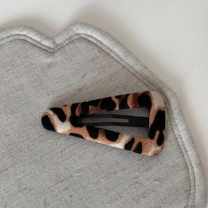 Close-up of leopard print fabric BB hair clip with elegant brown and black patterns