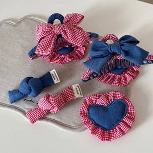 Detail of handmade denim and red plaid fabric bow hair claw set with heart charms