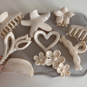 Collection of cream beige acrylic hair claws in assorted floral and heart shapes