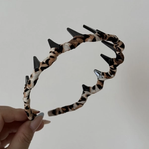 Detailed view of leopard print fabric headband featuring anti-slip black plastic inner teeth