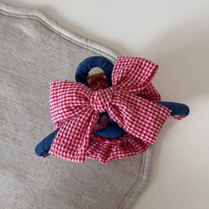 Close-up of red plaid and denim hair claw clip with large bow and ruffled edge detail