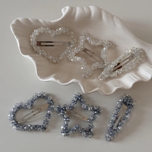 Détail de barrettes de luxe en cristal en forme d'étoile et de cœur sur coquillage