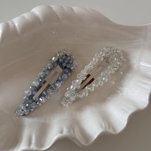 Gros plan d'élégantes pinces à cheveux en cristal et cœur sur un plateau décoratif