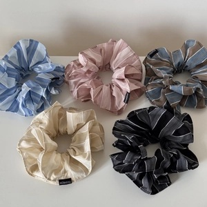 Détail d'un lot de cinq chouchous en tissu rayé avec étiquettes mode en couleurs variées