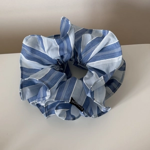 Gros plan détaillé du chouchou en tissu à rayures bleues et blanches avec étiquette