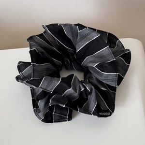 Gros plan d'un chouchou rayé noir et gris avec détail de l'étiquette Fashion