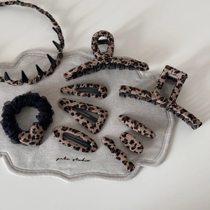Detail view of leopard print hair accessories set including large clips and headbands