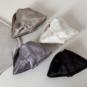 Close-up of satin bow hair claws featuring embossed rose patterns in four elegant colors