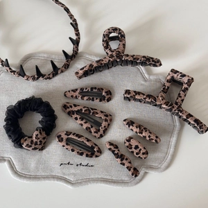 9-piece leopard print hair accessory set with fabric claw clips and scrunchie on soft base