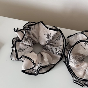 Beige floral jacquard scrunchie with black edge trim and large layered fabric ruffles