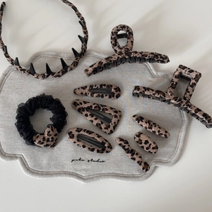 Flat lay of leopard print hair accessory set featuring claw clips and headbands
