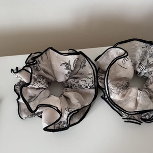 Two large off-white floral jacquard scrunchies with black edges for a minimalist look