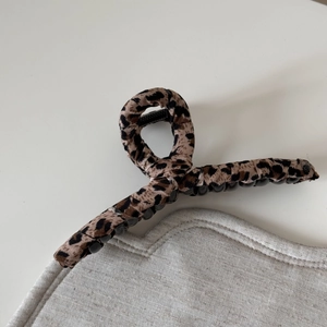 Close-up of leopard print fabric hair claw clip with black resin teeth for high-end styling