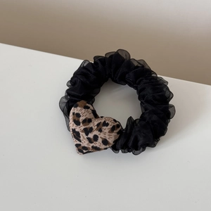 Detail of black mesh scrunchie featuring a leopard print fabric heart charm
