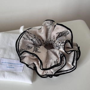 Close-up of oversized jacquard hair scrunchie with bamboo leaf patterns and gift pouch