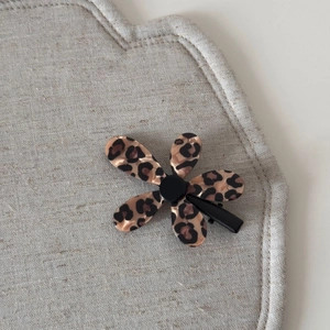 Vue détaillée de la pince à cheveux fleur léopard en résine avec clip métallique robuste