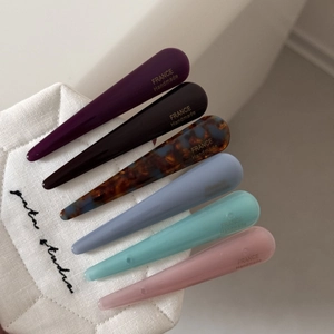 Détail de barrettes à cheveux en acétate colorées avec lettrage doré fait main