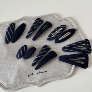 Detailed set of navy blue and striped fabric wrapped metal hair clips in various shapes