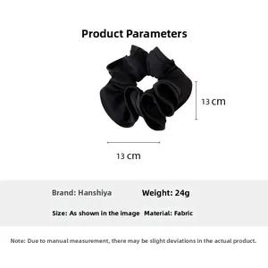 Detail of a black oversized scrunchie measuring 13cm with soft ruffled fabric texture
