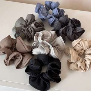 Close-up of pleated elastic scrunchies in various Morandi colors and knit fabric textures