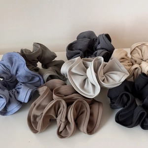 Close-up of assorted colorful ribbed fabric scrunchies in neutral earth tones
