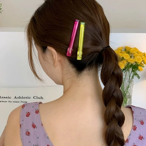 Neon pink and yellow acetate hair pins set on braided hair for elegant women styling