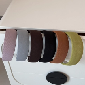 Vue détaillée de six serre-têtes en tissu rayé de couleurs assorties suspendus à un tiroir