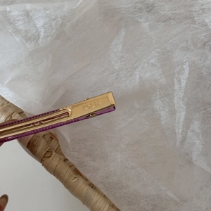 Close-up of translucent purple acetate hair clip with engraved gold Korea metal clasp