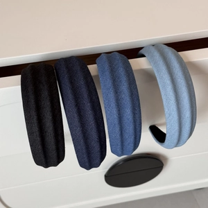 Detail of four denim fabric headbands showing textured ribbing and gradient blue tones