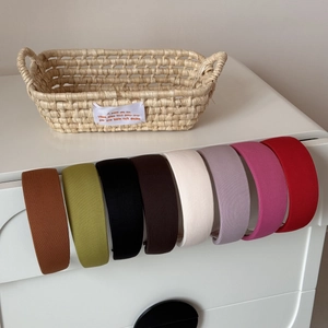 Détail de serre-têtes larges rayés en huit couleurs variées sur un tiroir blanc élégant