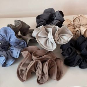 Detailed macro view of assorted knitted scrunchies in various soft neutral colors