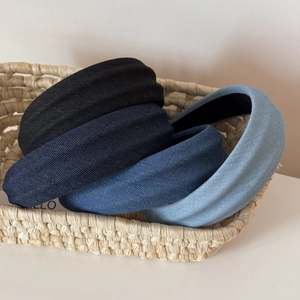 Three padded denim headbands in black and blue colors inside a straw basket