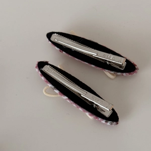 Détail de barrettes à cheveux à carreaux rouges et blancs avec dents en métal argenté