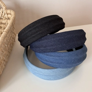 Detail of four denim wide headbands in black and blue shades with thick padded texture