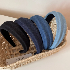 Detail view of five assorted denim fabric headbands with thick texture in a woven basket
