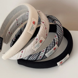 Détail de quatre serre-têtes en tissu avec écussons fraises et motifs à carreaux