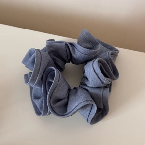 Close-up of a large blue-grey vintage cotton scrunchie with layered fabric textures