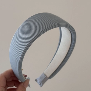 Gros plan d'un serre-tête tricoté bleu clair à rayures avec doublure intérieure blanche