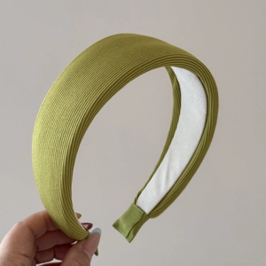 Vue détaillée de la texture du tissu rayé vert olive sur un serre-tête large rembourré