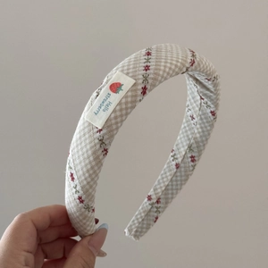 Détail de l'étiquette fraise et du tissu à carreaux sur le serre-tête rembourré
