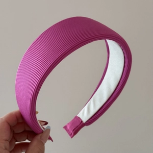 Détail d'un serre-tête en tissu côtelé fuchsia avec doublure intérieure blanche