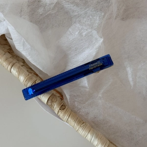 Close-up of handmade dark blue acetate hair clip with gold France lettering and metal spring