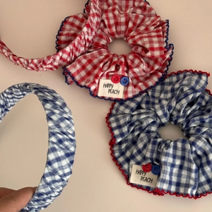Set aus rot-blauen karierten Haargummis mit bunten Knöpfen und Stoffetiketten