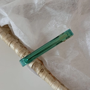 Macro detail of translucent seafoam green acetate hair clip with gold France handmade logo