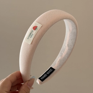 Détail du serre-tête rembourré rose avec étiquette fraise et logo fait à la main