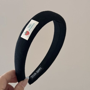 Détail du serre-tête noir rembourré avec écusson Hello Strawberry et étiquette Handmade