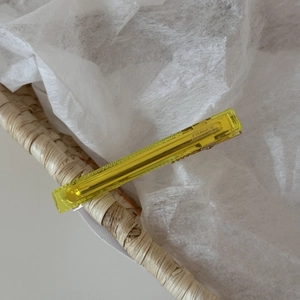 Detail of yellow acetate hair clip with silver metal base and France engraving