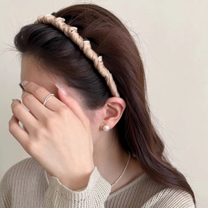 Elegant champagne satin ruffled headband for women worn by a model in a side view