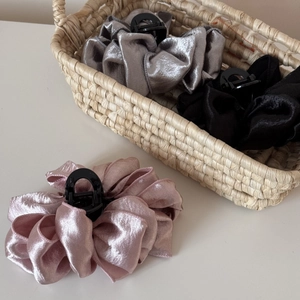 Detail of pink and grey pleated satin fabric hair claws inside a woven basket