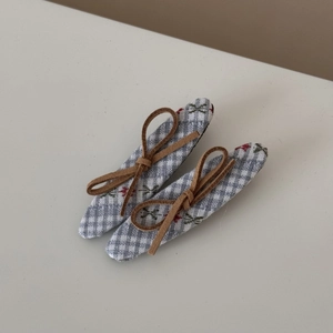 Détail de pinces à cheveux à carreaux floraux avec nœud en daim marron pour femme